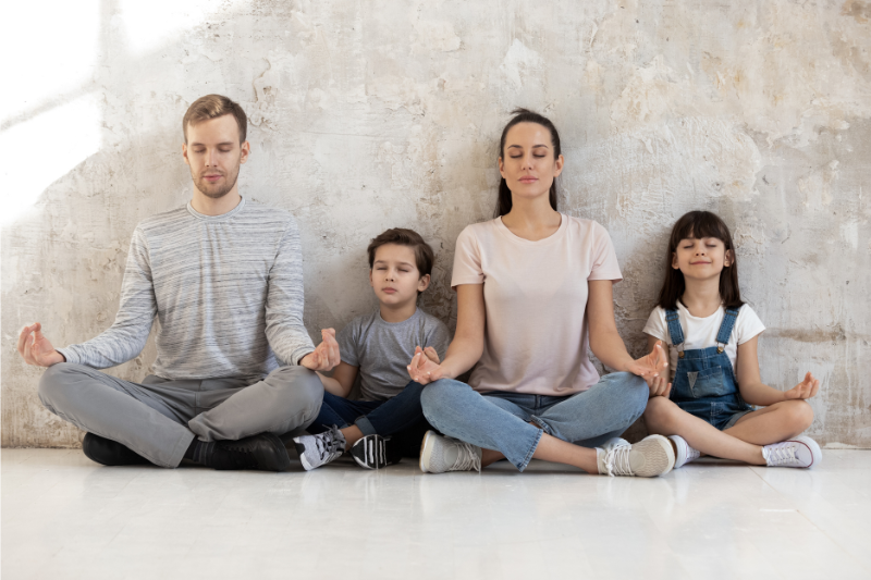 parents meditating with their 2 young kids: how to become spiritual awakening with kids